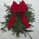 Close-up texture of handcrafted evergreen teardrop arrangement featuring fragrant fir boughs